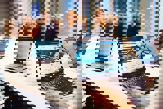 Møterom med bærbare datamaskiner og personer som sitter rundt et møtebord. Foto: Cecilie Bannow.