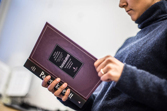 En person leser i boken Pasientskaderett. Foto: Ådne Sinnes.