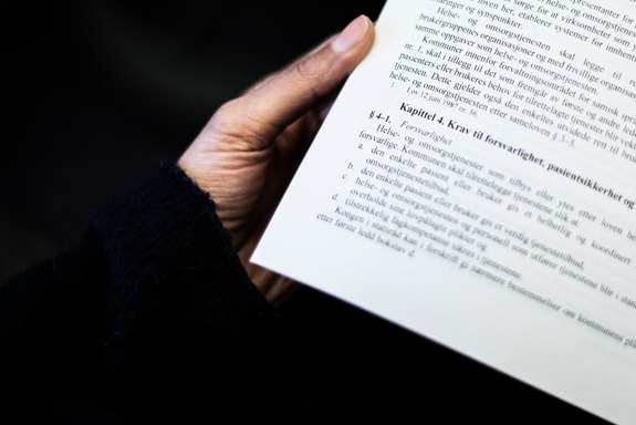 En person leser i helse- og omsorgstjenesteloven. Foto: Ådne Sinnes.