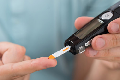 En person sjekker blodsukkernivået ved å stikke seg i fingeren med en måler. Illustrasjonsfoto: Mostphotos.