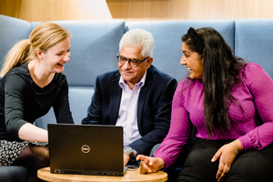 Tre personer sitter foran en PC. Foto: Cecilie Bannow.