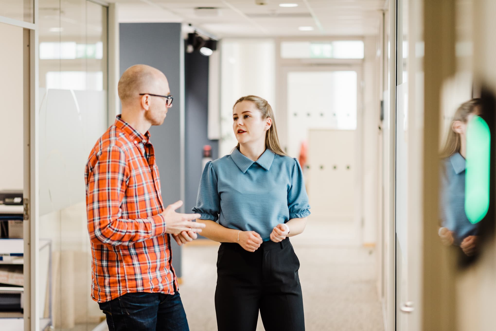 Ei kvinne og ein mann står og snakkar saman. Foto: Cecilie Bannow.