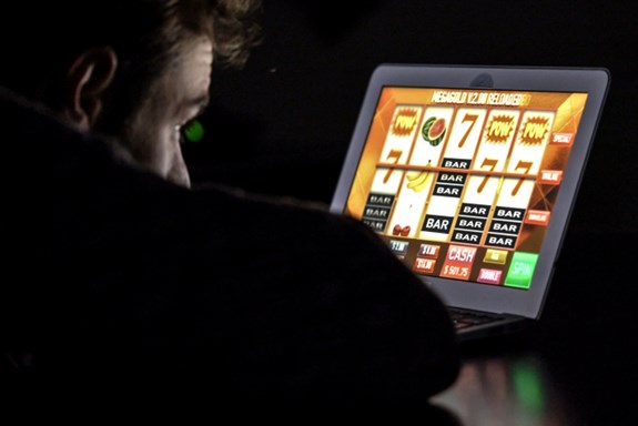 Illustrasjonsbildet syner ein mann som sit framfor ein PC-skjerm og speler eit pengespel. Foto: Mostphotos.