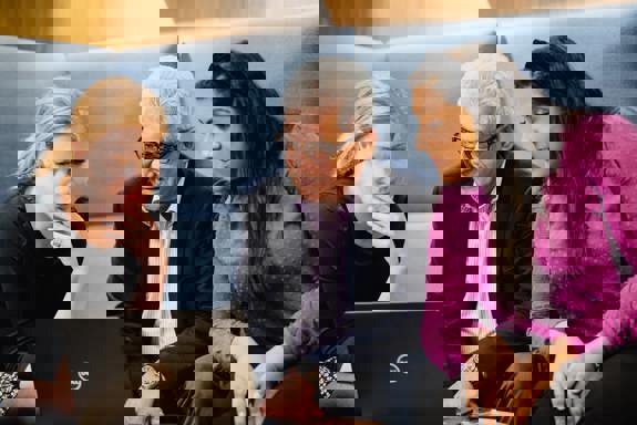 Tre personer sitter sammen og ser på en PC. Foto: Cecilie Bannow.