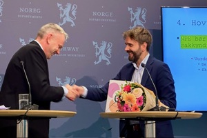 Leder for ekspertgruppen overleverer rapporten til helse- og omsorgsministeren.