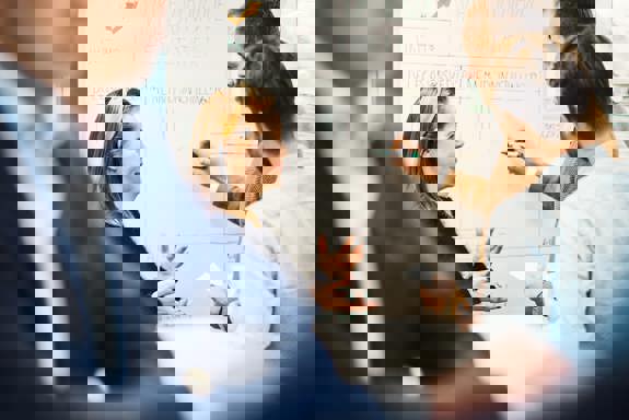 Tre personer står foran en tavle. Foto: Cecilie Bannow.