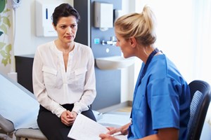 Bildet syner ein lege og ein pasient under ein konsultasjon. Begge er kvinner.